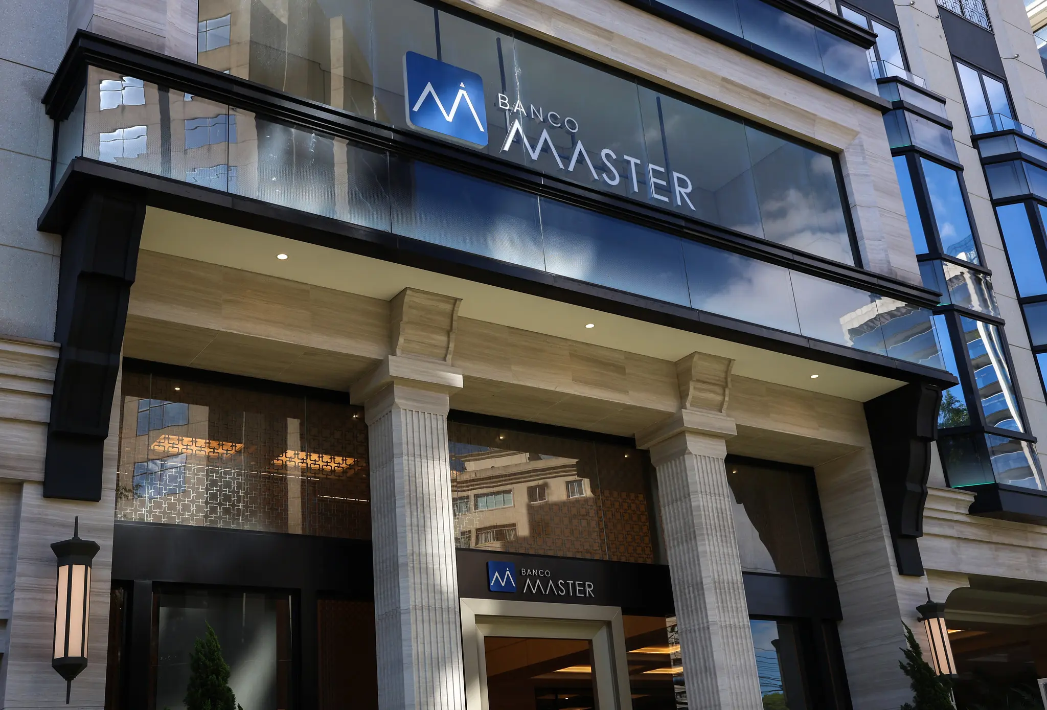 Entrada de agência do Banco Master em área urbana durante o dia.